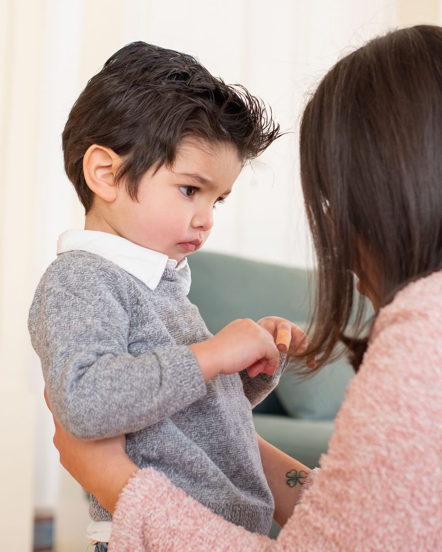 A parent speaking gently with an upset young child at eye level